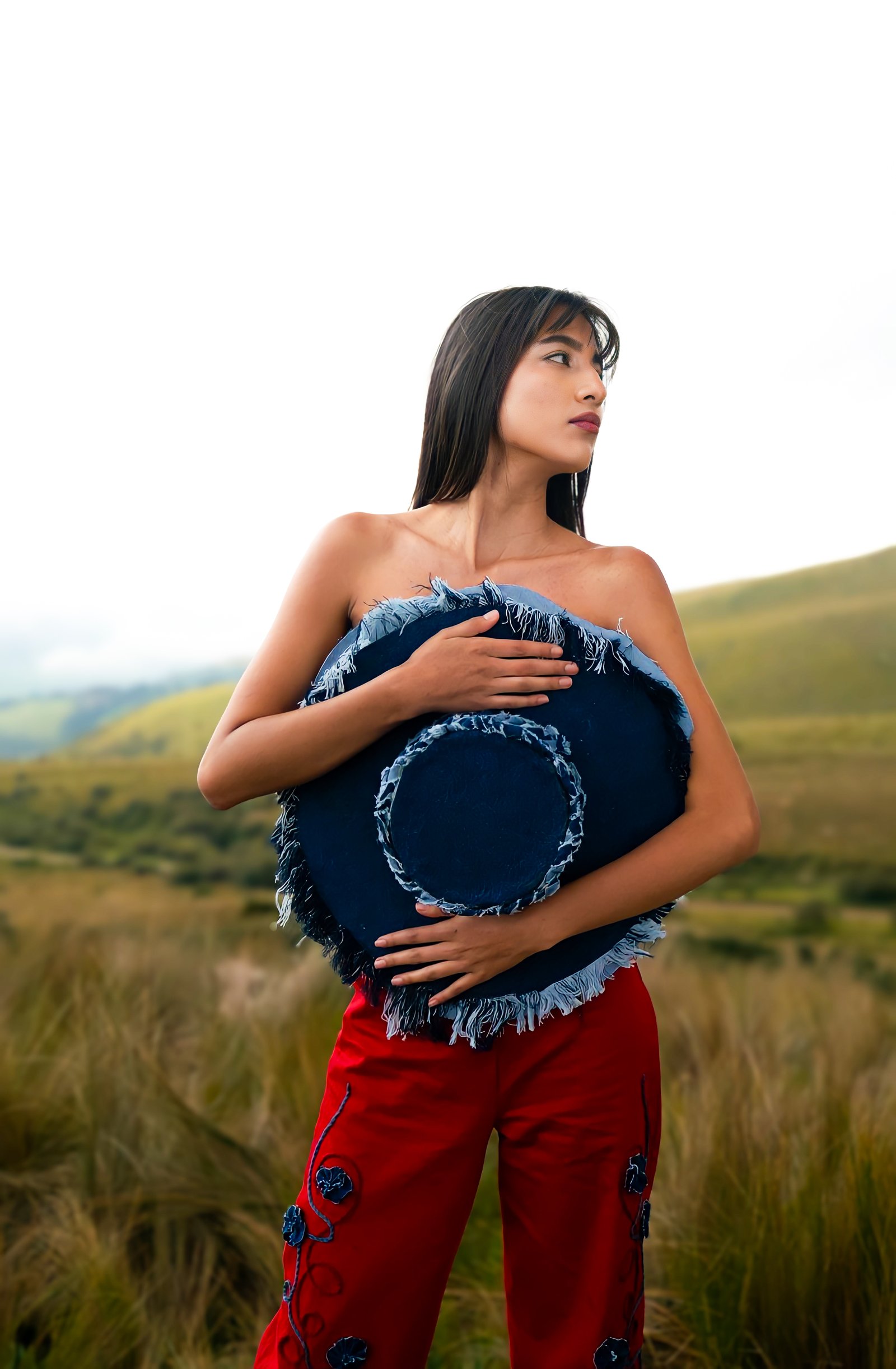 Modelo sosteniendo un sombrero de denim en el paisaje andino