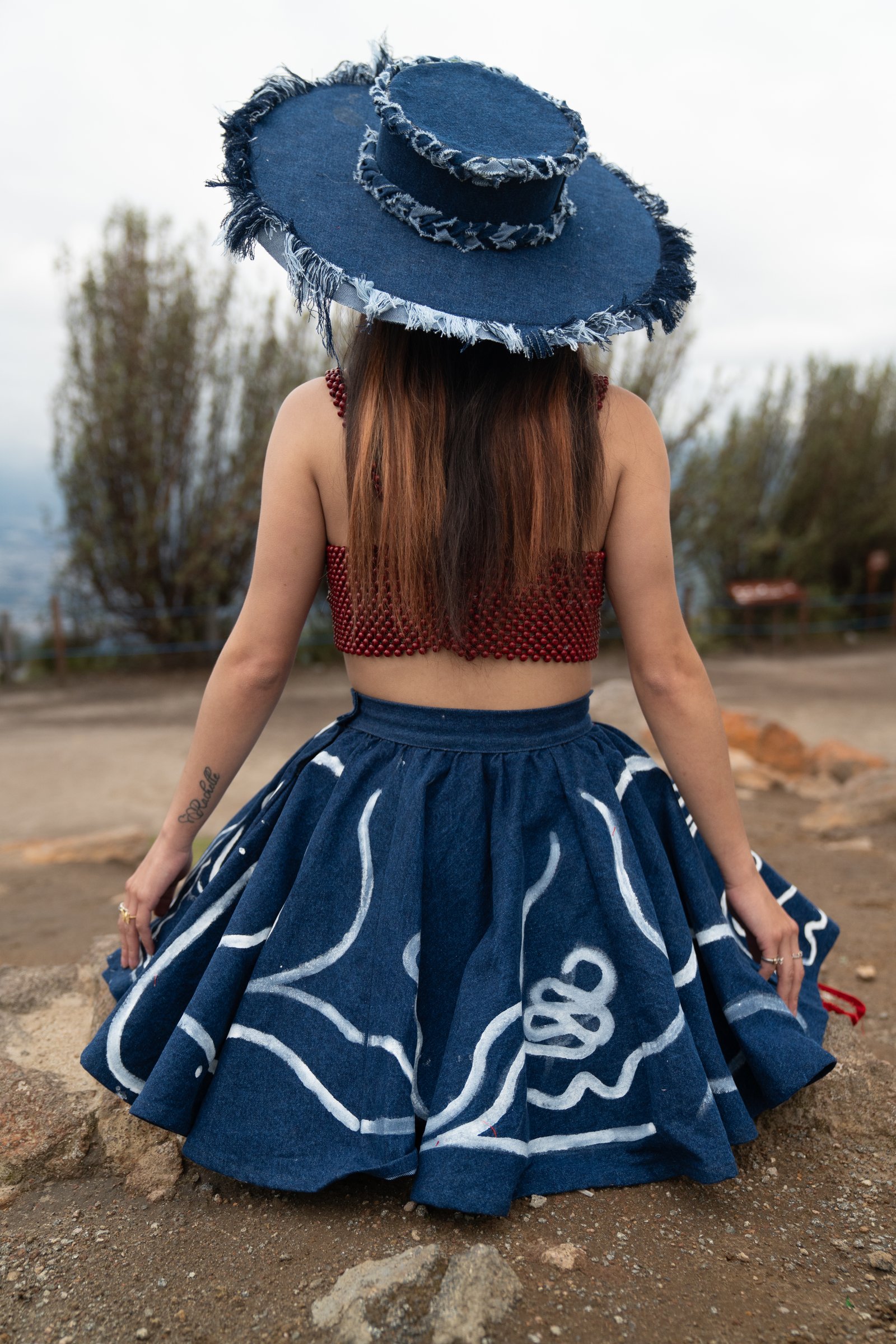 Vista posterior de un conjunto de denim azul y cuentas rojas