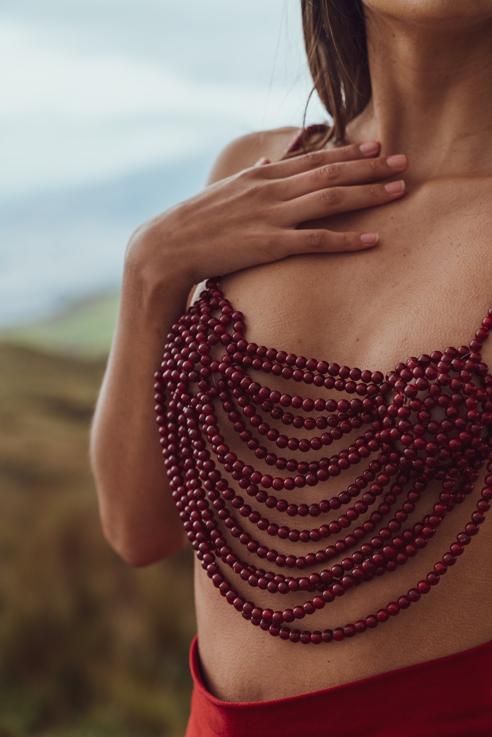 Detalle de un top artesanal elaborado con cuentas rojas